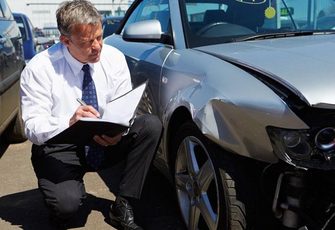 young man filling out paperwork for auto insurance